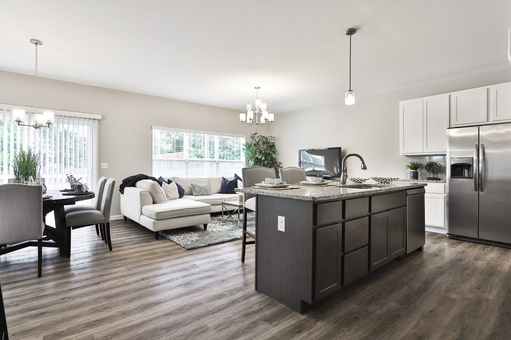 a kitchen and living room with a refrigerator and a sink