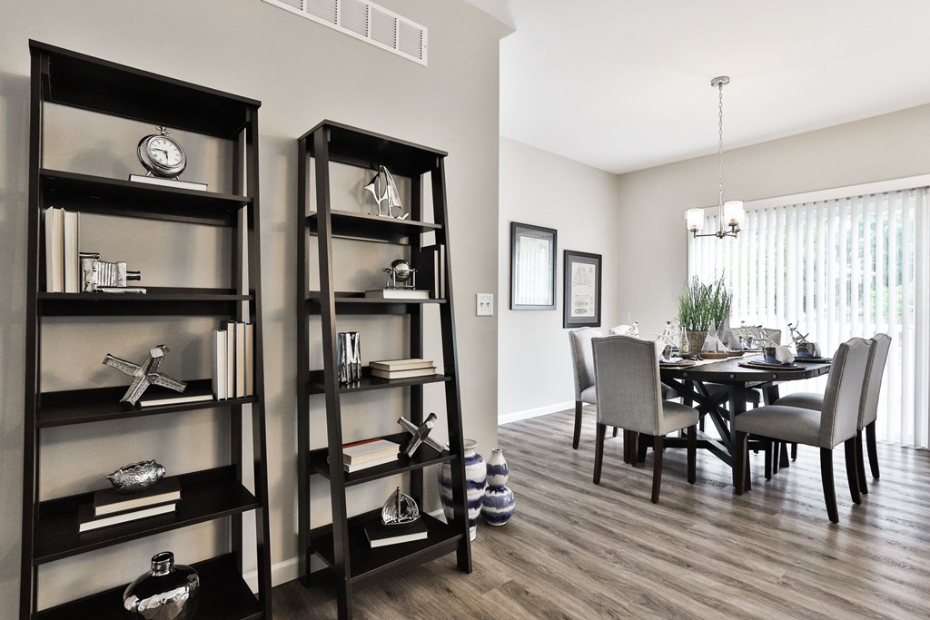 a living room and dining room with a table and chairs and shelves