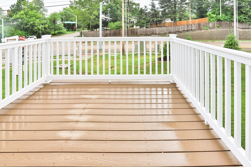 the deck has a white railing and a wood floor
