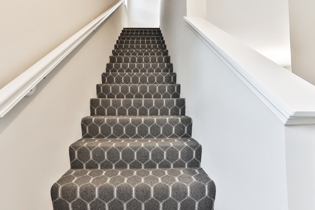 an image of a staircase with a tiled stair carpeting up the side of