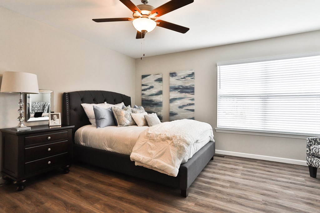 a bedroom with a bed and a ceiling fan
