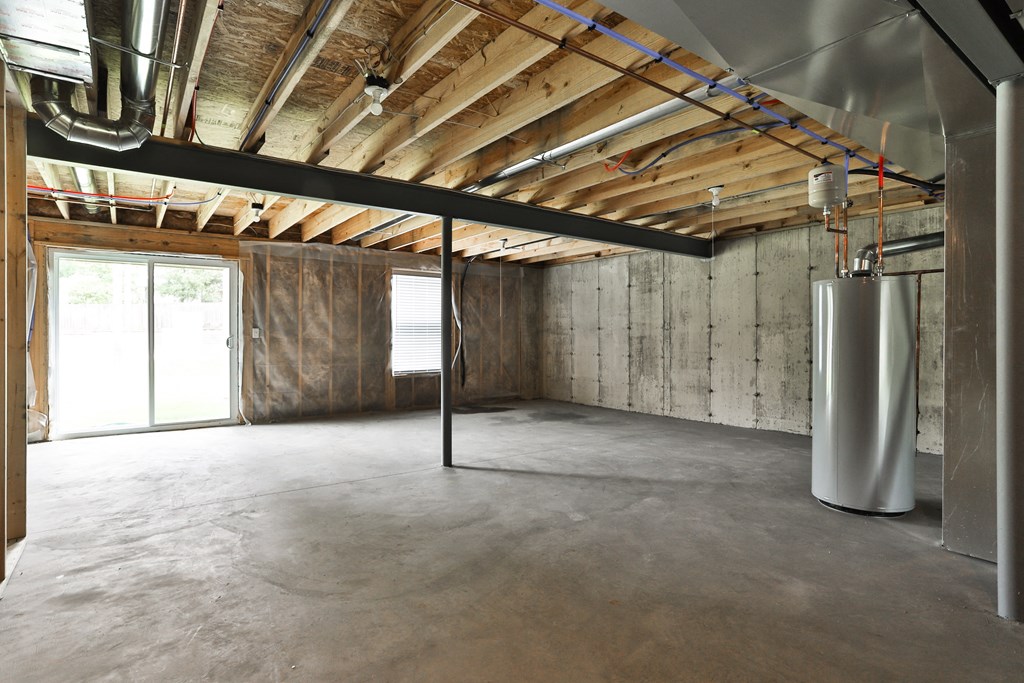 a room with a concrete floor and exposed wood ceilings