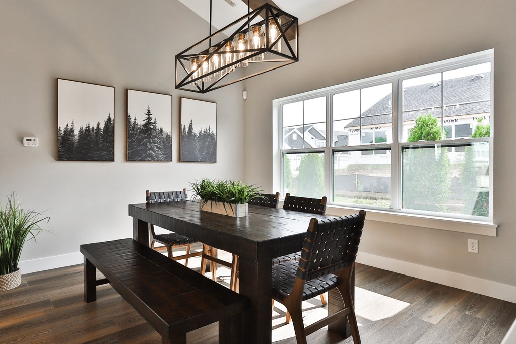 a dining room with a table and chairs and a large window