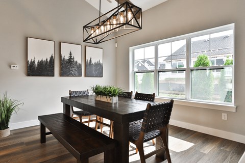 a dining room with a table and chairs and a large window