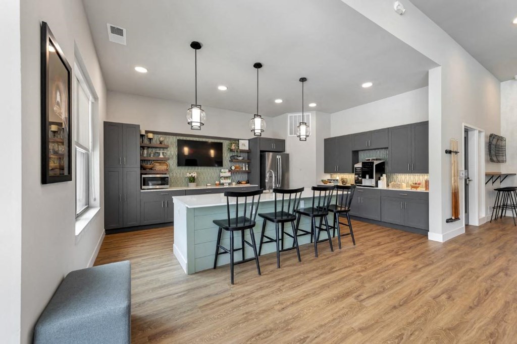 a kitchen and dining room with a counter and chairs at The Prairie Luxury Apartments, Dardenne Prairie Missouri
