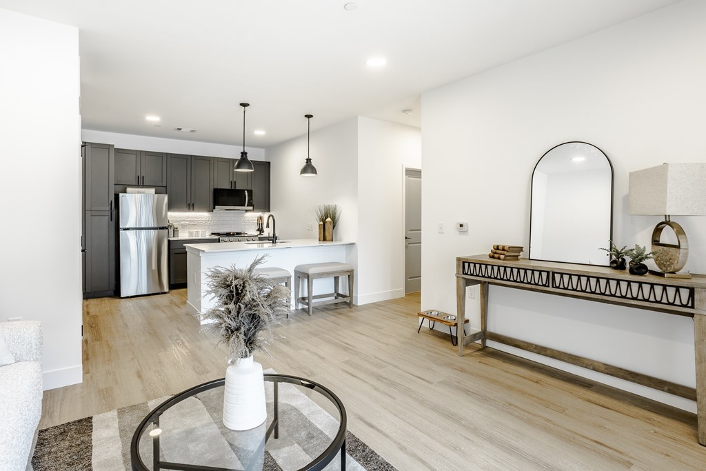 A modern kitchen with a glass table and a white fridge.