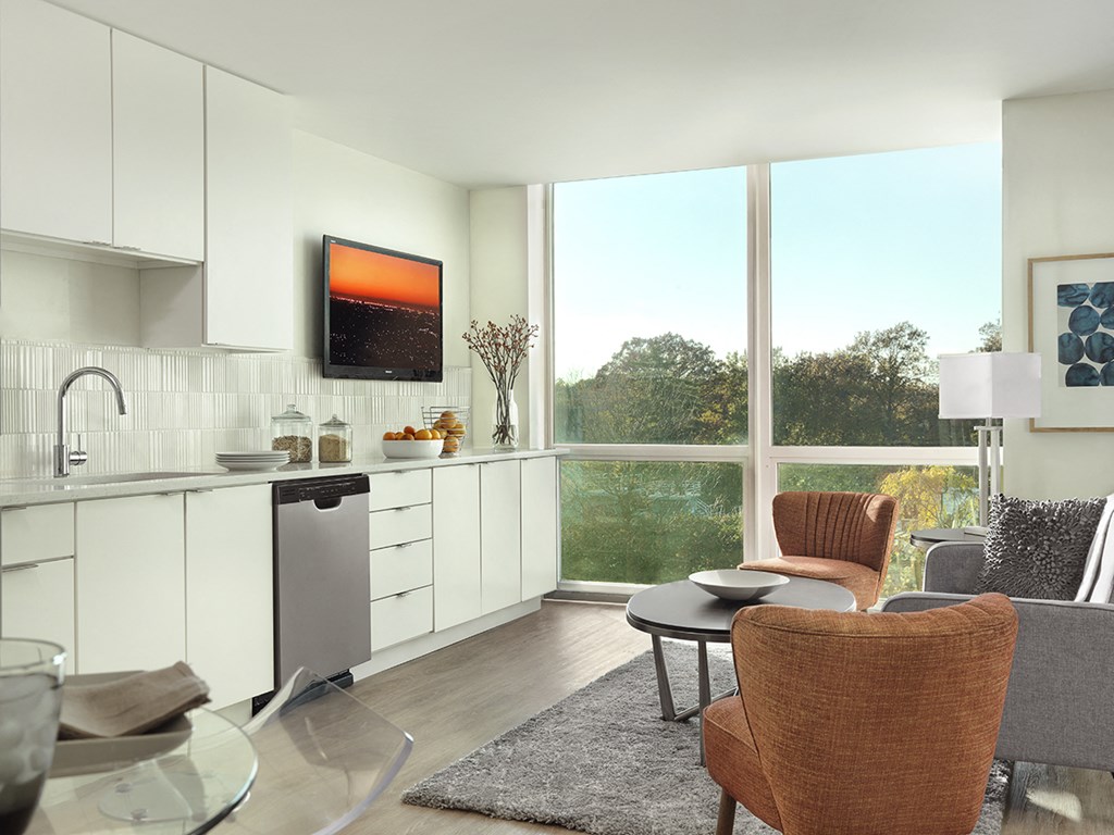 Apartment kitchen with white cabinets and floor-to-ceiling window  at Clayton On The Park, Clayton, MO, 63105