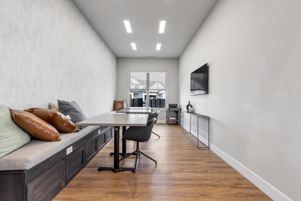 a dining room with a table and chairs and a wall mounted tv at The Prairie Luxury Apartments, Missouri, 63368