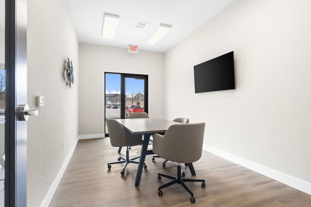a conference room with a table and chairs and a television at The Junction at Rogers, Rogers, 72756
