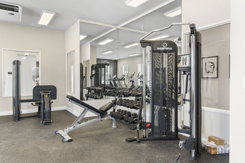 a gym with weights and cardio equipment in a building at The Junction at Rogers, Rogers