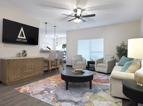 A living room with a rug on the floor and a sign that says "ARTIAN" on the wall.