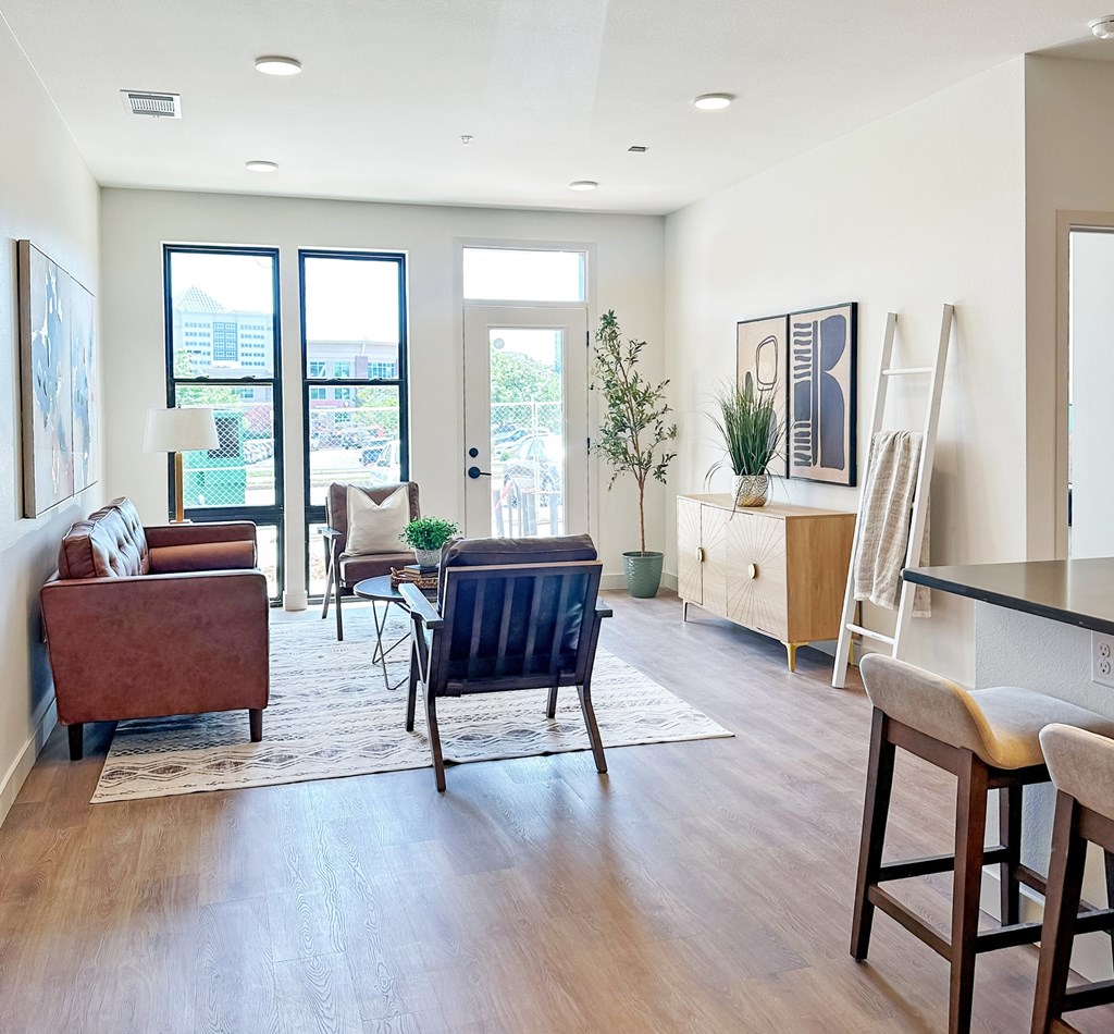 A living room with a brown chair and a blue chair in the middle of the room.