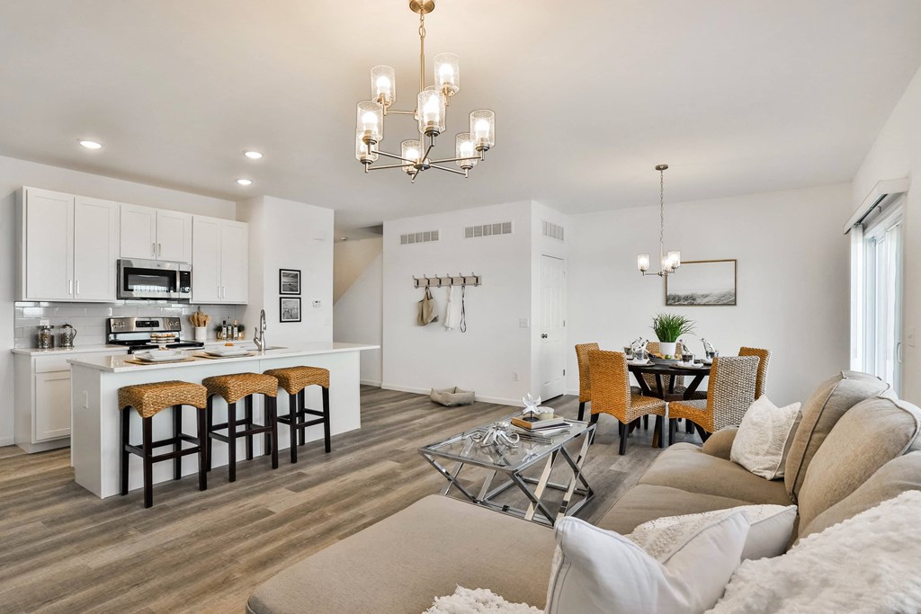 a living room and kitchen with a couch and a table at The Prairie Villas, Dardenne Prairie, MO