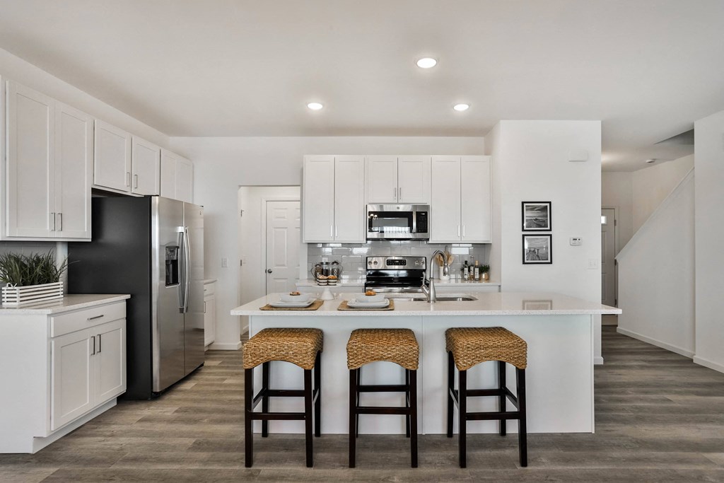 a kitchen with a large island with three stools at The Prairie Villas, Missouri