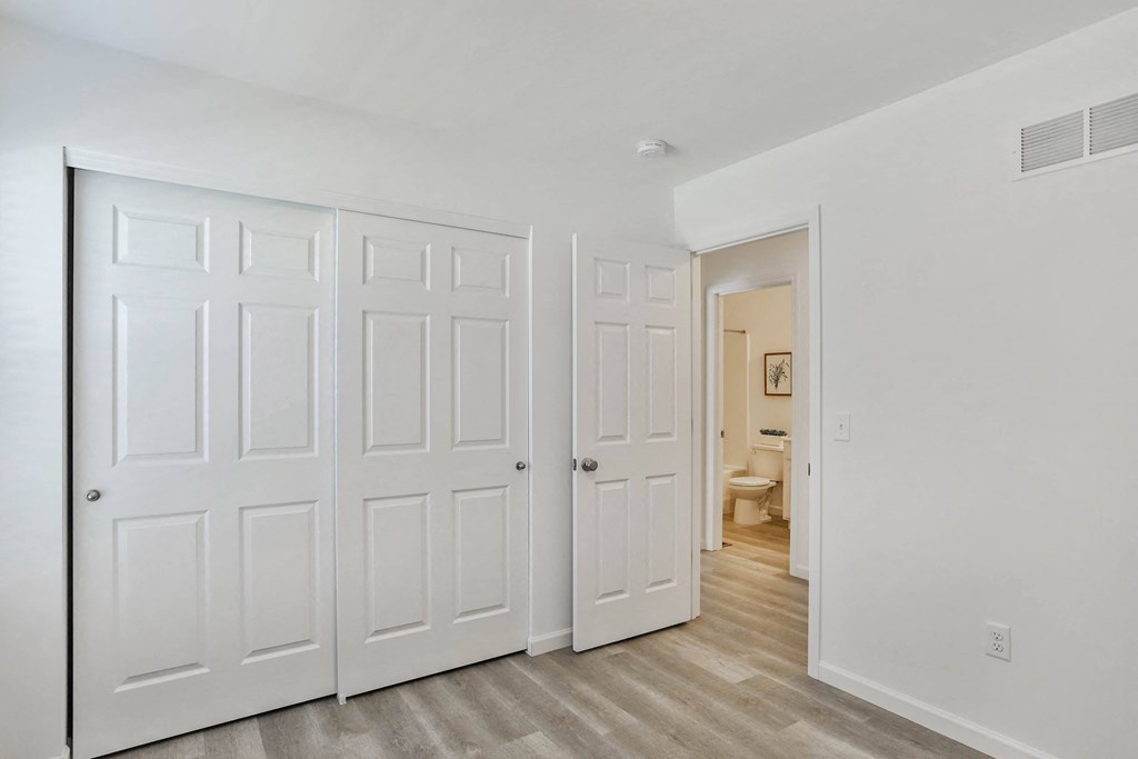 a bedroom with two closets and a door to a bathroom at The Prairie Villas, Dardenne Prairie, MO