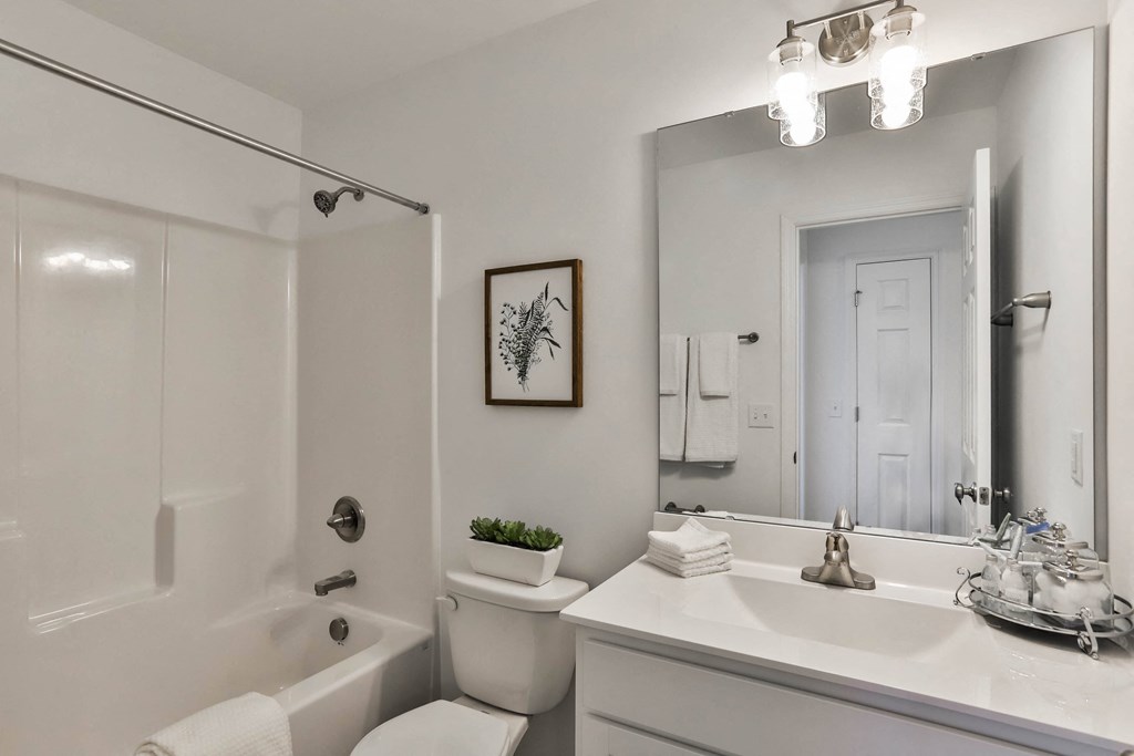 a bathroom with a large mirror and a sink and a toilet at The Prairie Villas, Dardenne Prairie, MO 63368