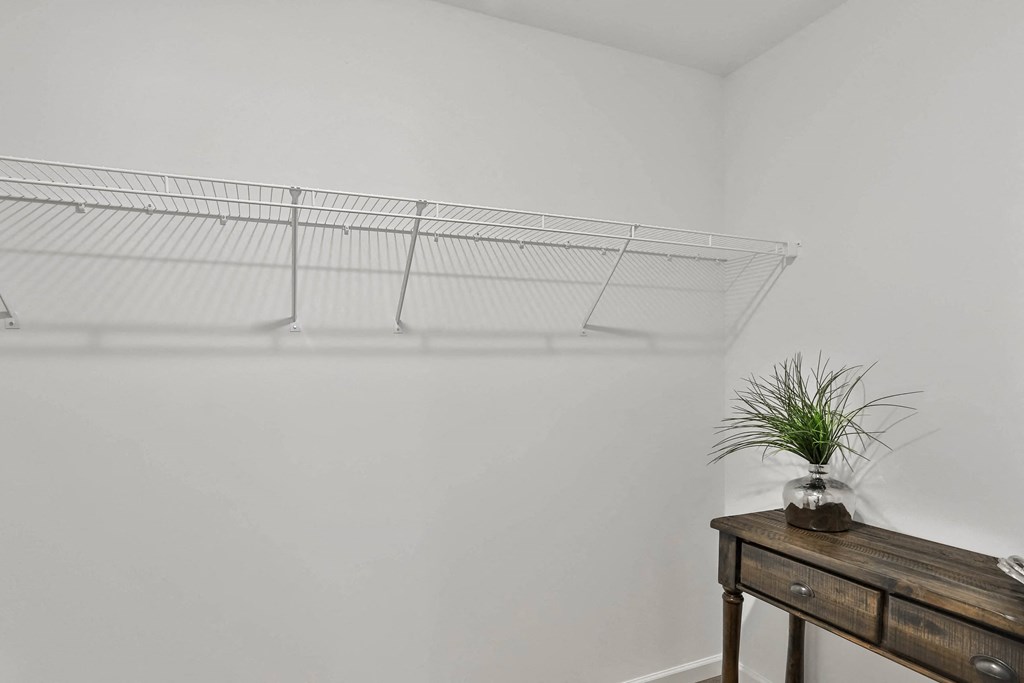 a white room with a wooden table and a shelf with a plant at The Prairie Villas, Missouri