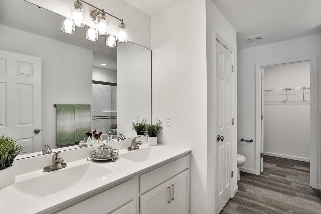 a bathroom with a large mirror and a white sink at The Prairie Villas, Dardenne Prairie