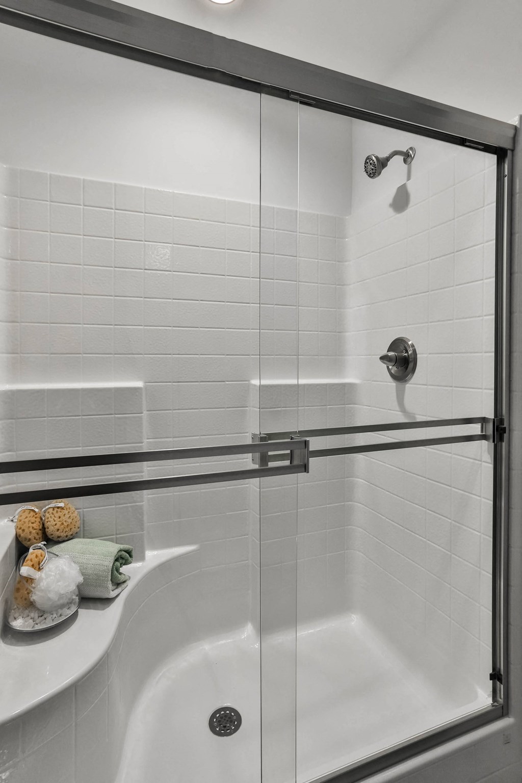a white bathroom with a shower and a sink at The Prairie Villas, Dardenne Prairie, Missouri