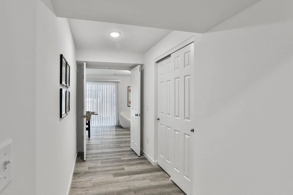 a long white hallway with white doors and a door to a bathroom at The Prairie Villas, Dardenne Prairie, MO