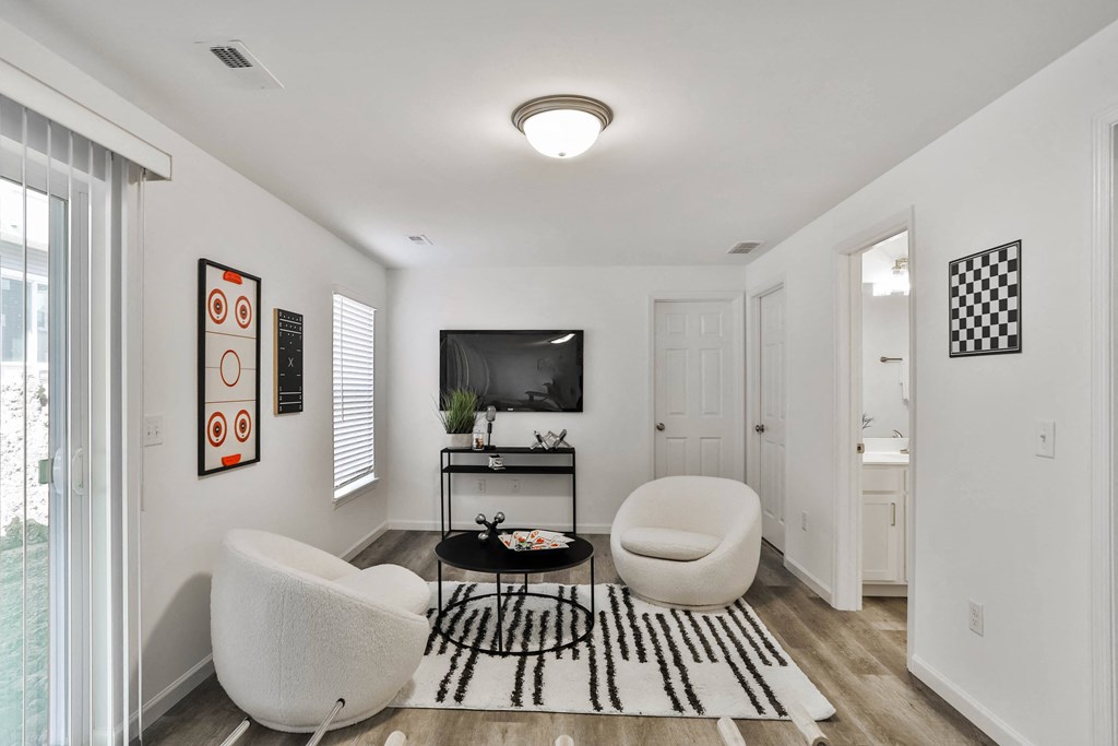 a living room with two white chairs and a television at The Prairie Villas, Missouri