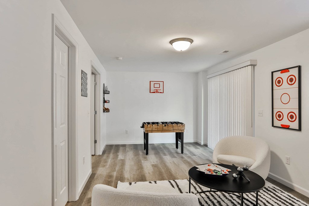 a living room with white walls and white furniture and a game table at The Prairie Villas, Dardenne Prairie, MO 63368