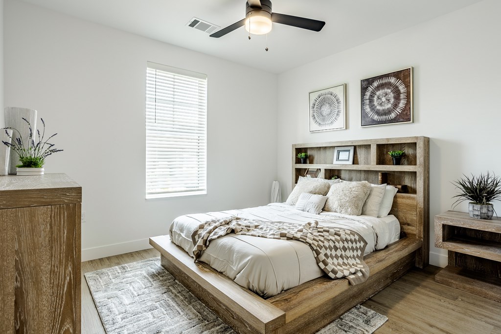 A bedroom with a bed, a wooden nightstand, and a ceiling fan at Prairie Encore, Dardenne Prairie, MO 63368