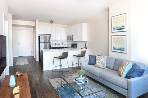 a living room with a couch and a kitchen