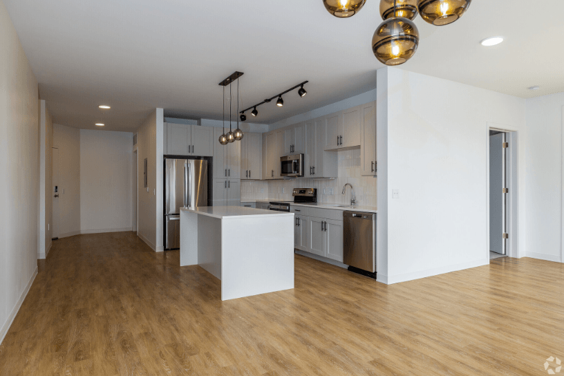 a kitchen and dining area with white cabinets and light colored hardwood flooring, at 2200 LaSalle, St Louis, 63104