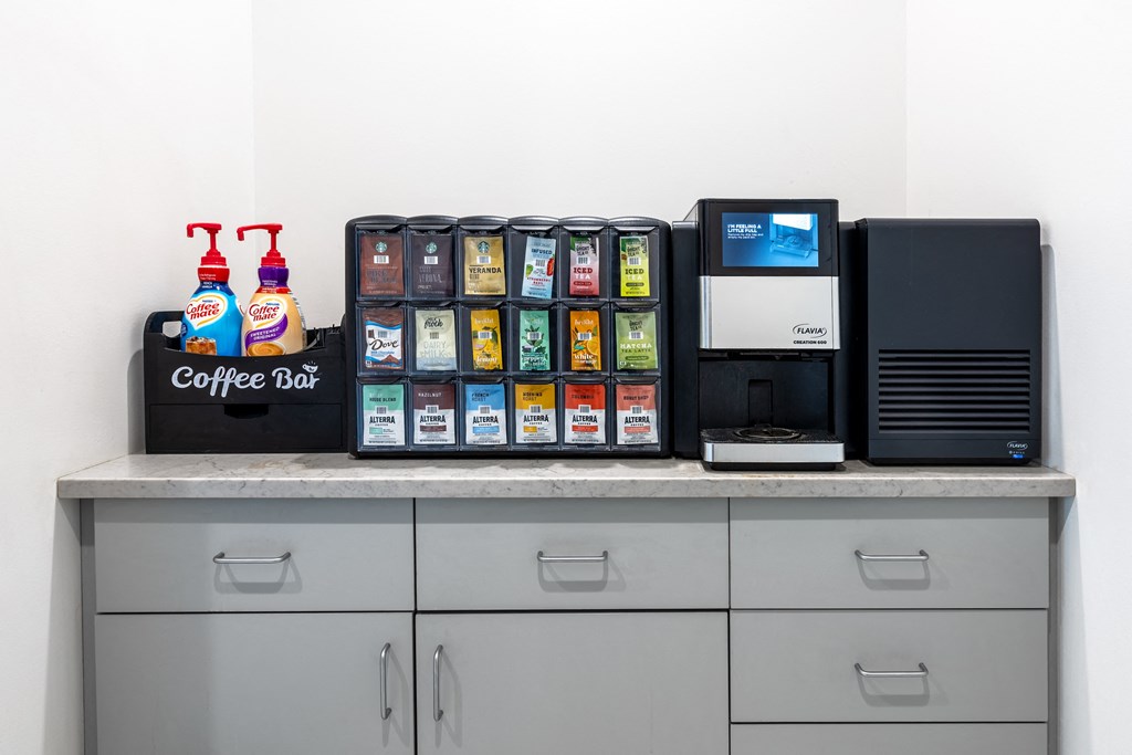 a coffee bar with a microwave and other items on a counter at 2200 LaSalle Apartments, St Louis