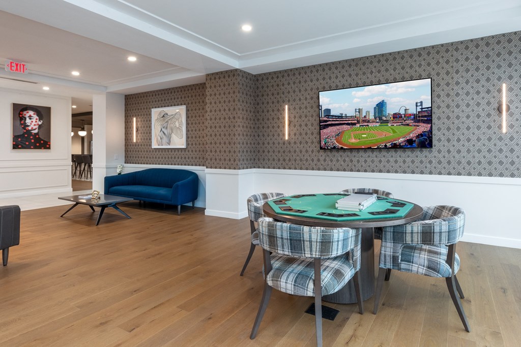 a dining room with a table and chairs and a tv on the wall at 2200 LaSalle Apartments, St Louis, Missouri