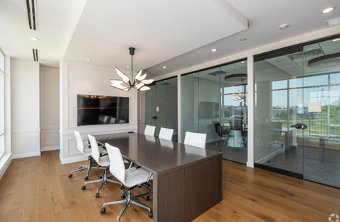 a large conference table with white chairs and a large tv on the wall at 2200 LaSalle, St Louis, Missouri