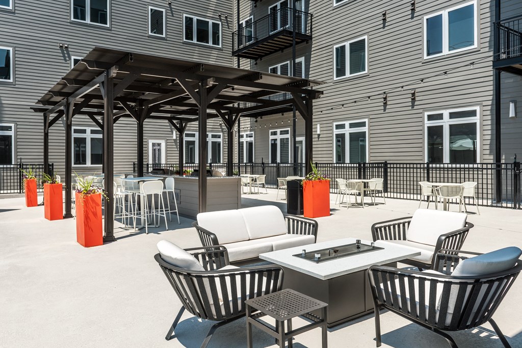 an outdoor patio with chairs and tables and a grill at 2200 LaSalle Apartments, Missouri