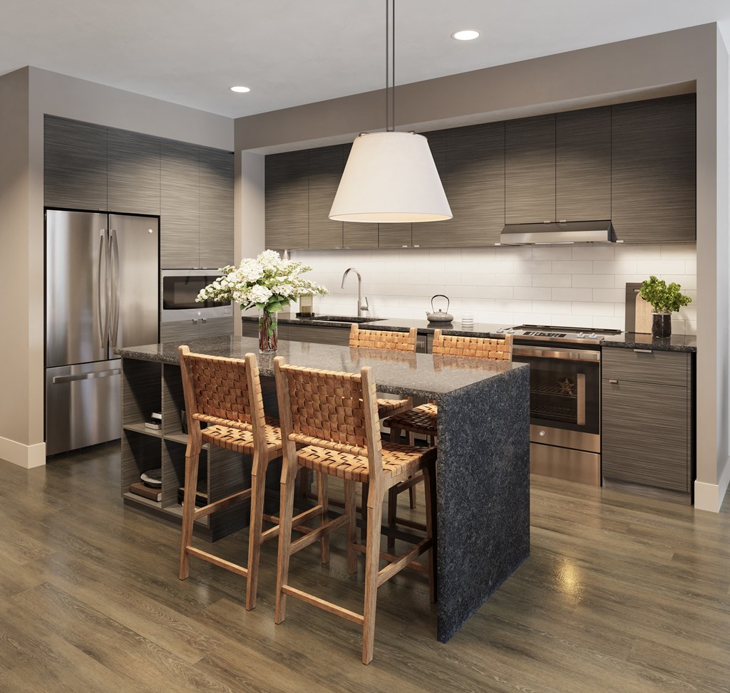 a kitchen with a large island and a table with chairs at Bemiston Place Apartments, Clayton, MO
