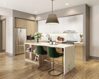 a kitchen with white cabinets and a white island with green chairs at Bemiston Place Apartments, Missouri