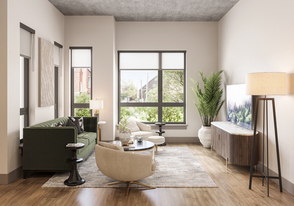 a living room with a large window and a green couch at Bemiston Place Apartments, Clayton Missouri