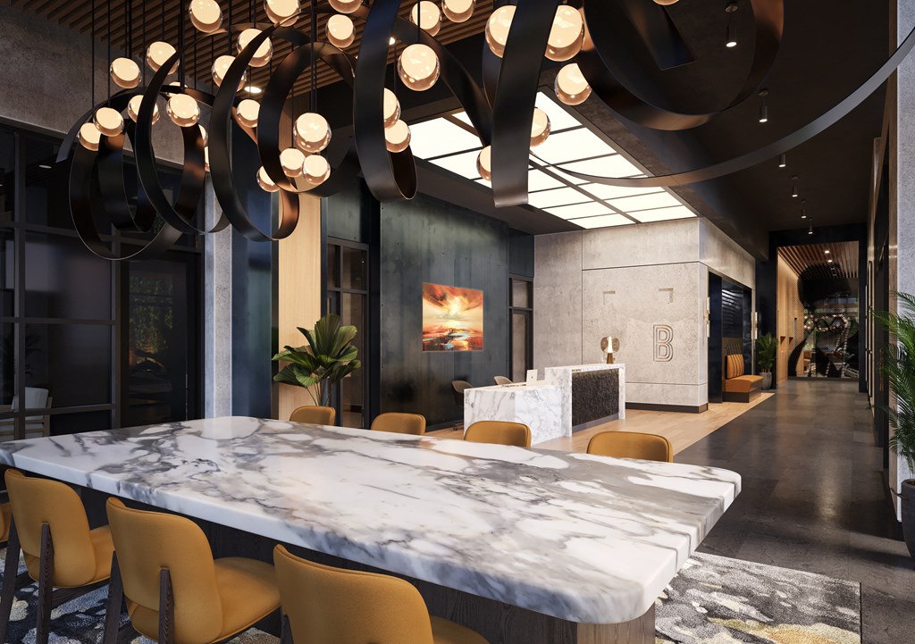 a large marble table in the middle of a room with yellow chairs at Bemiston Place Apartments, Clayton, MO 63105 