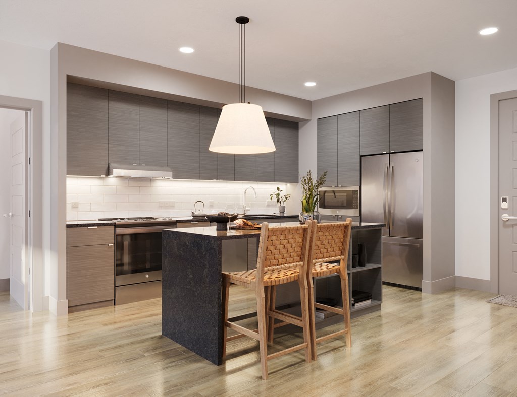 a large kitchen with a black island and wooden chairs at Bemiston Place Apartments, Missouri