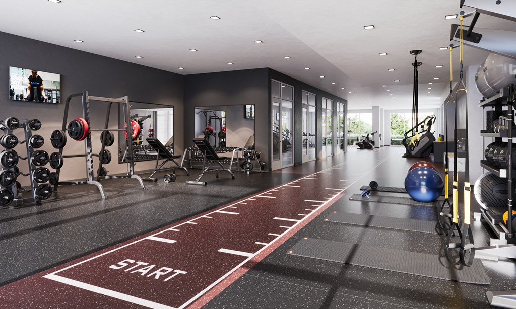a workout room with treadmills and weights on the floor