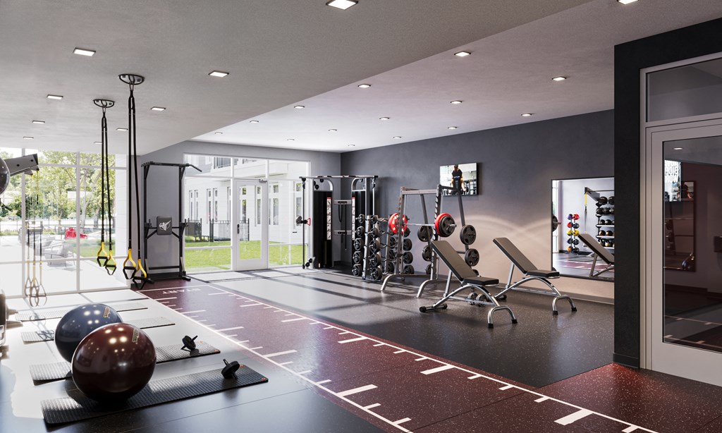 a home gym with a lot of equipment and a large window