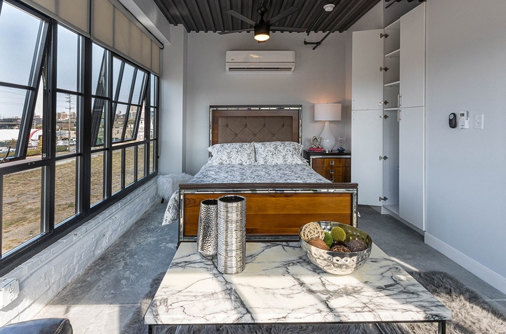 a bedroom with a bed and a table with a bowl of fruit