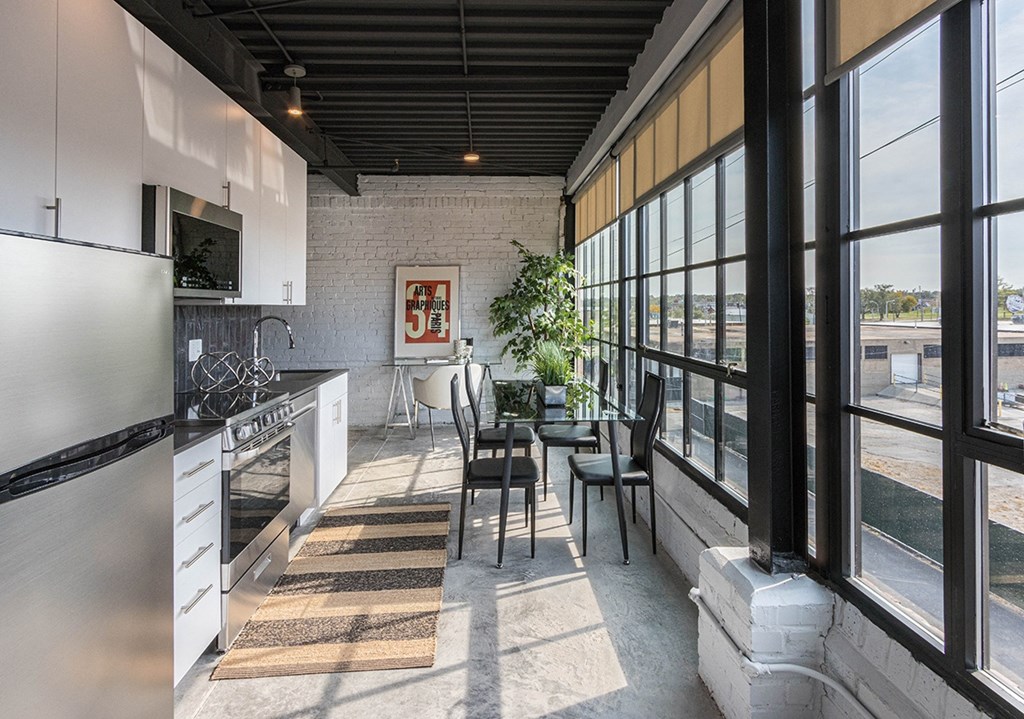 a kitchen and dining area with large windows and a table and chairs
