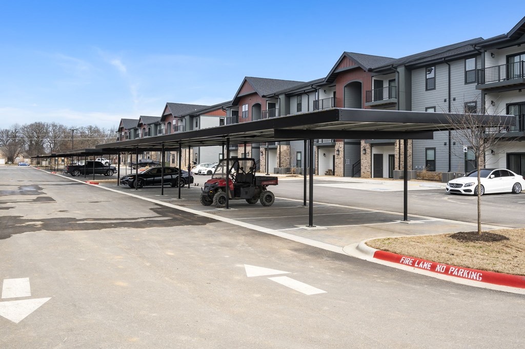 an empty parking lot in front of a row of apartment buildings at The Junction at Rogers, Rogers, AR