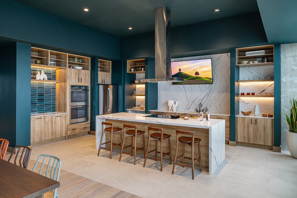 A modern kitchen with a large island and wooden bar stools.