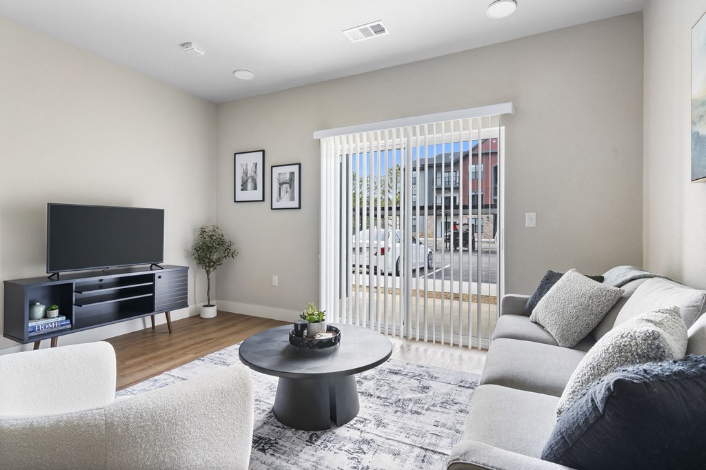 a living room with a couch and a tv at The Junction at Rogers, Rogers, AR
