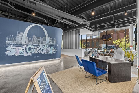 A room with a blue chair and a table with a sign that says "STE COTE".