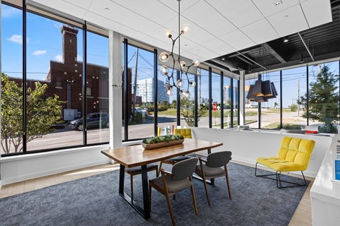 A dining room with a table and chairs and a view of the outside.