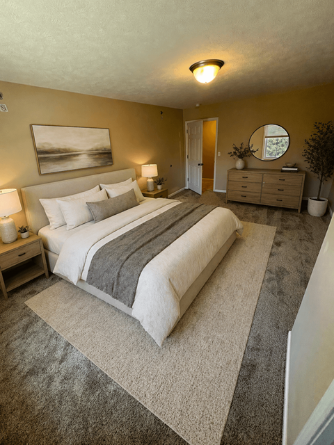 A bedroom with a large bed and a painting on the wall.