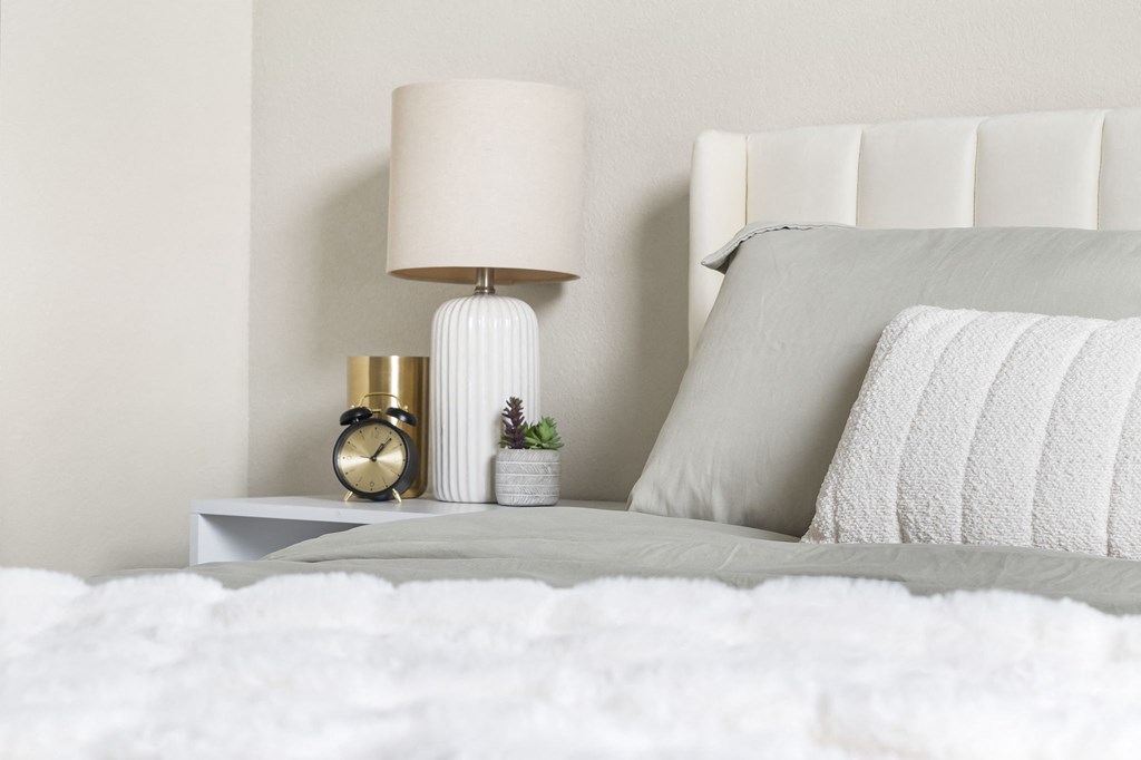 a white bed with white bedding and a white nightstand with a white lamp at The Junction at Rogers, Rogers, Arkansas