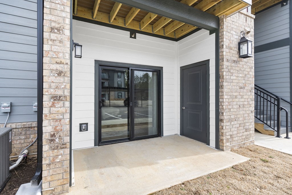 the front porch of a home with a black door at The Junction at Rogers, Rogers